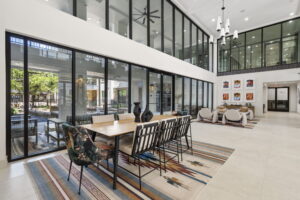 Open room with panoramic glass windows, dining table and accent chairs